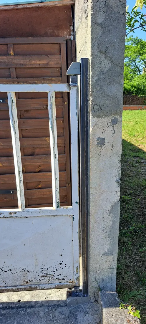Grille de défense métallique en cours de pose sur une fenêtre