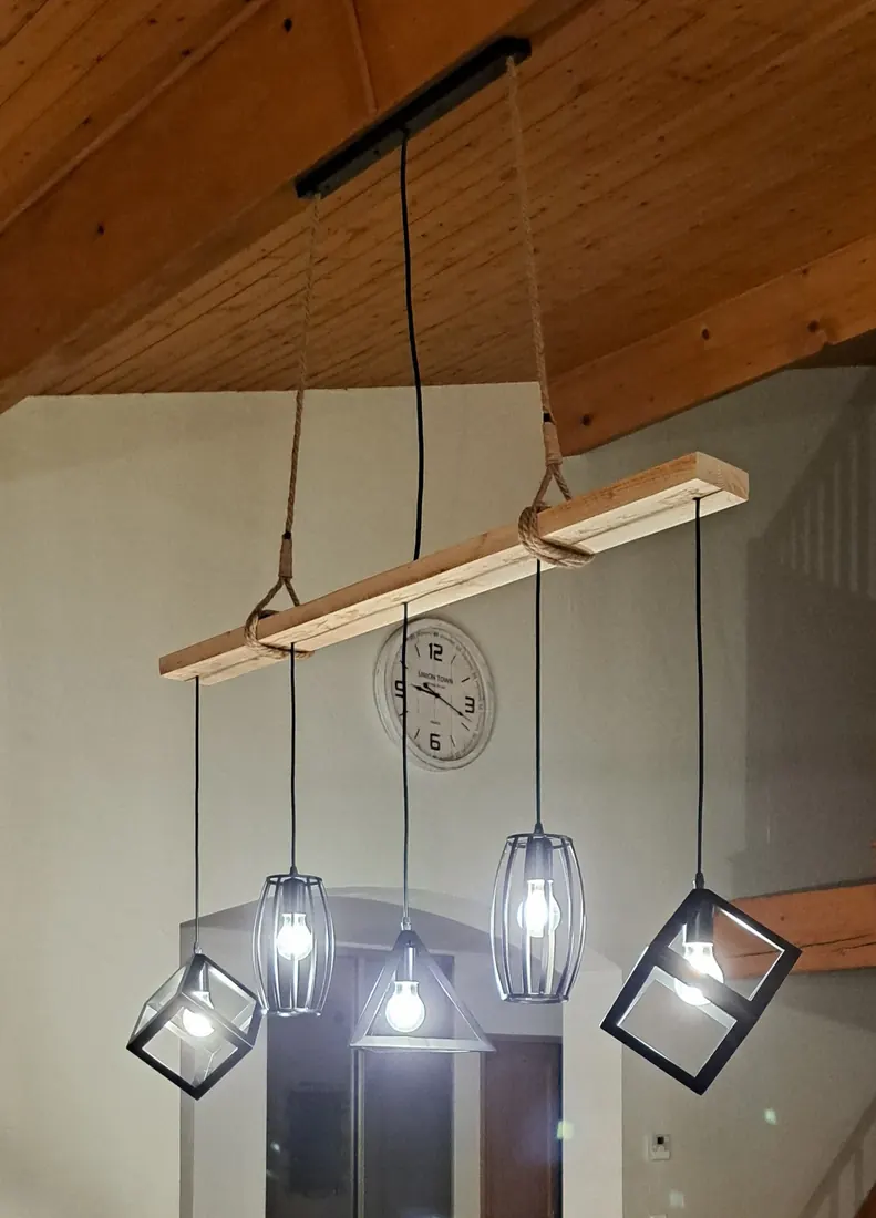 Suspension luminaire fixée sur une poutre bois dans un séjour