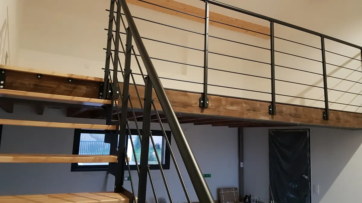 Mezzanine en bois et garde-corps métallique installés sous charpente